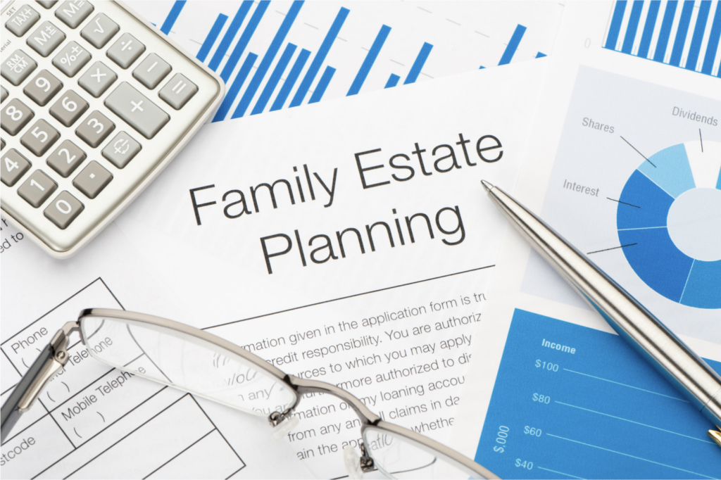 A close-up view of a family estate planning document on a desk, surrounded by a calculator, eyeglasses, a pen, and charts with financial data, symbolizing organization and financial planning.